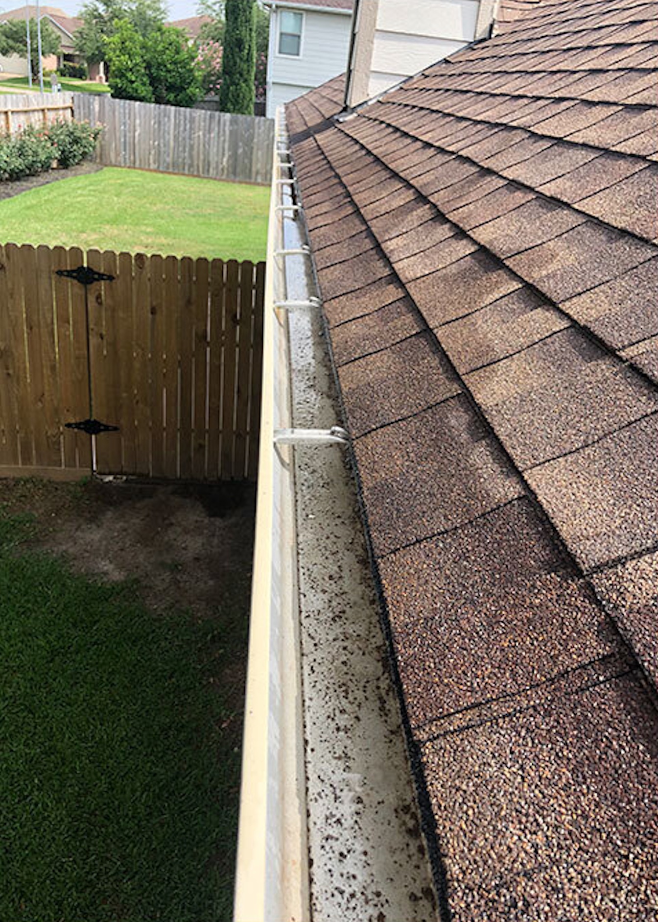 After: Gutter cleaning before and after showing debris removal and brightening